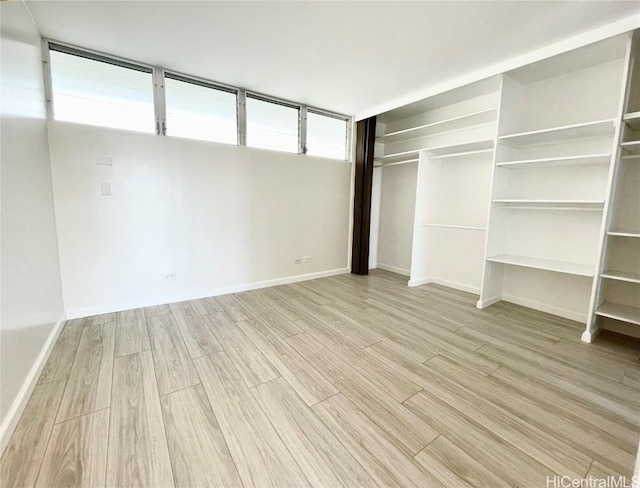 unfurnished bedroom featuring light hardwood / wood-style flooring and a closet