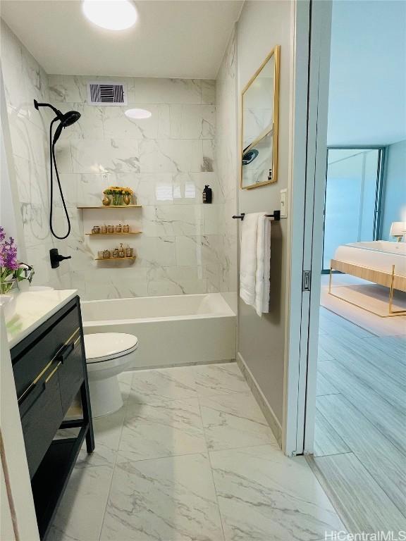 full bathroom with vanity, tiled shower / bath, and toilet