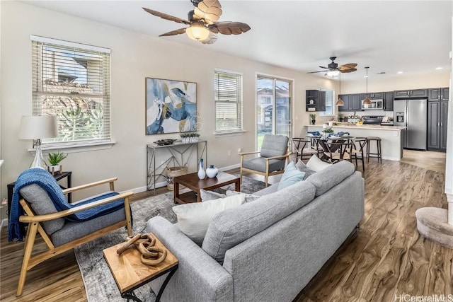 living room featuring hardwood / wood-style flooring, ceiling fan, and a wealth of natural light