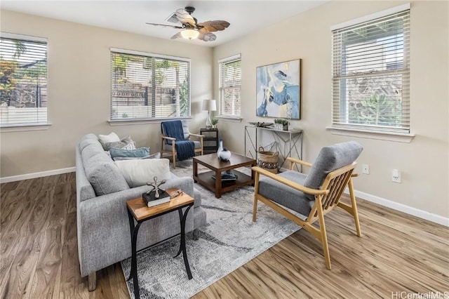 living area with hardwood / wood-style flooring, ceiling fan, and a healthy amount of sunlight