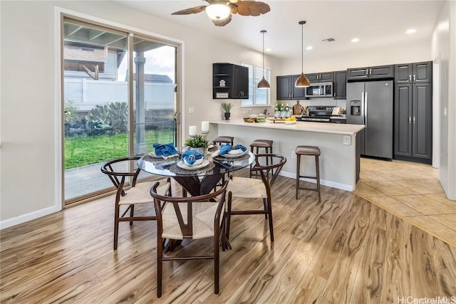 dining space with ceiling fan and light hardwood / wood-style flooring