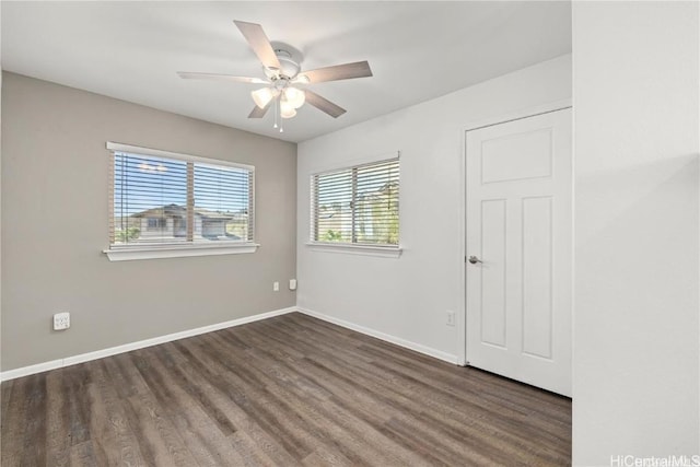 empty room with dark hardwood / wood-style floors and ceiling fan