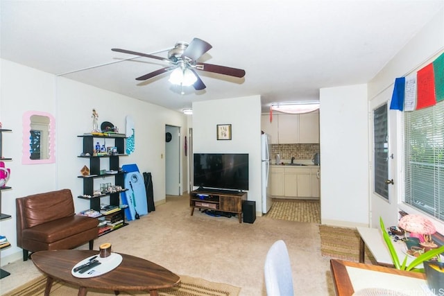 living room featuring ceiling fan, sink, and light carpet