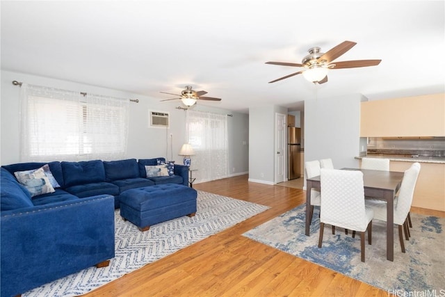 living room with an AC wall unit, hardwood / wood-style floors, and ceiling fan