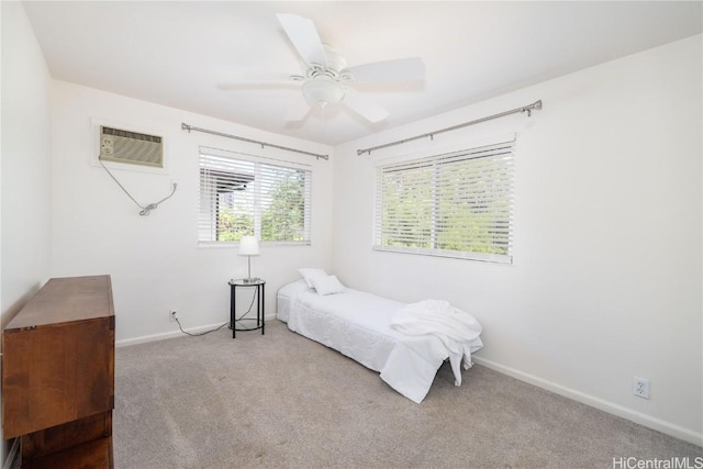 bedroom featuring ceiling fan, light colored carpet, and a wall mounted air conditioner