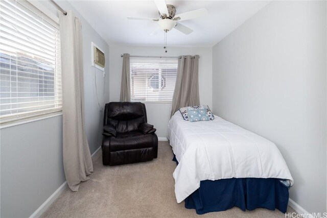 carpeted bedroom featuring a wall mounted AC and ceiling fan