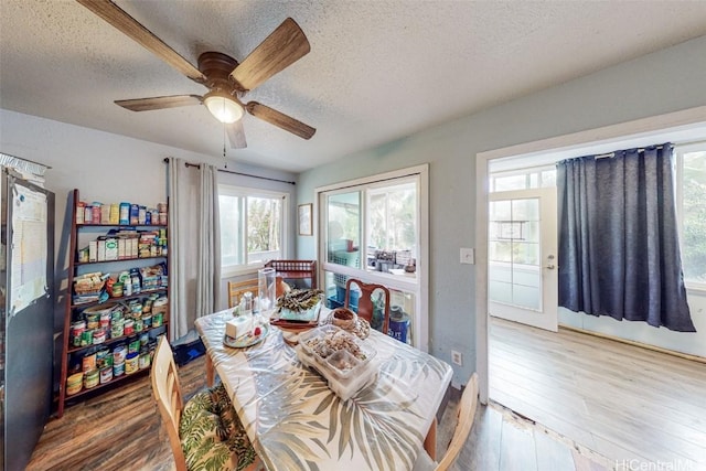 dining area with hardwood / wood-style floors, a textured ceiling, and ceiling fan