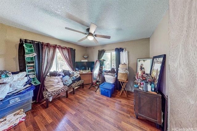 misc room with dark wood-type flooring, ceiling fan, plenty of natural light, and a textured ceiling