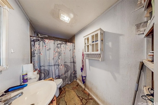 bathroom featuring walk in shower, sink, and toilet