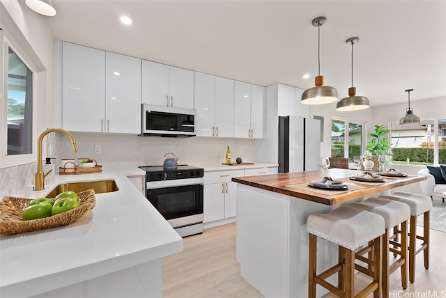 kitchen with white cabinetry, sink, and electric range oven