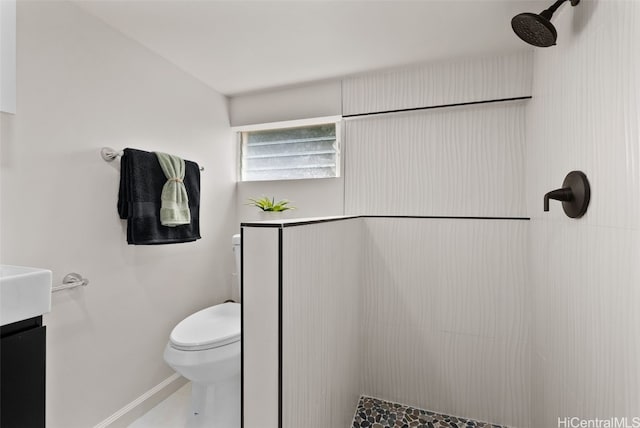 bathroom with vanity, toilet, and a tile shower