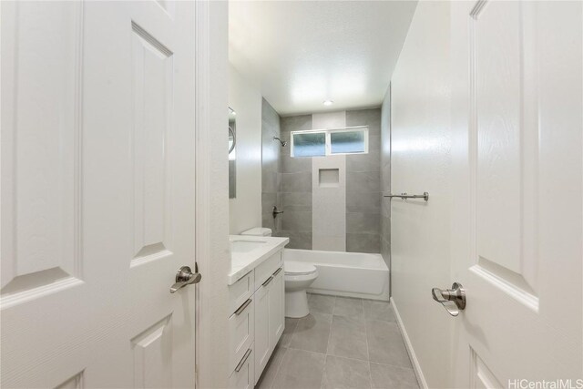 full bathroom featuring tile patterned floors, vanity, toilet, and tiled shower / bath combo