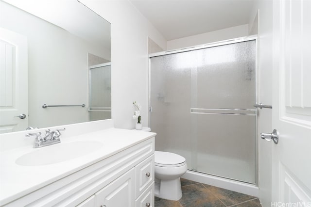 bathroom with vanity, toilet, and a shower with shower door