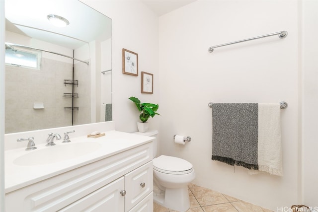 bathroom with toilet, vanity, and tile patterned floors