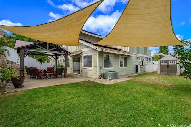 rear view of property with cooling unit, a gazebo, a patio area, a yard, and a shed