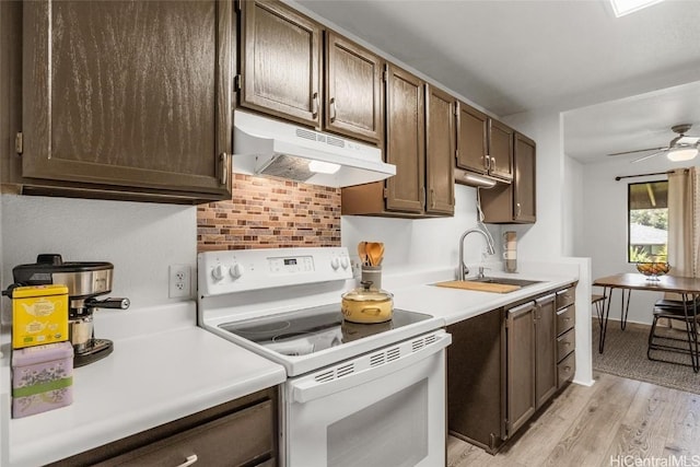 kitchen with dark brown cabinets, white range with electric cooktop, and sink