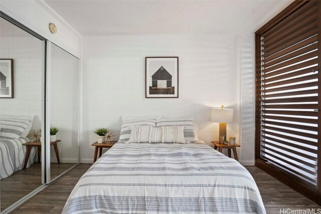 bedroom featuring dark hardwood / wood-style floors, a closet, and ornamental molding