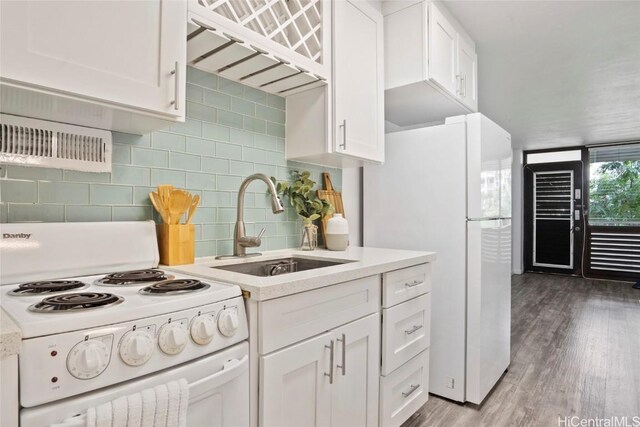 kitchen featuring tasteful backsplash, sink, white cabinets, and white appliances