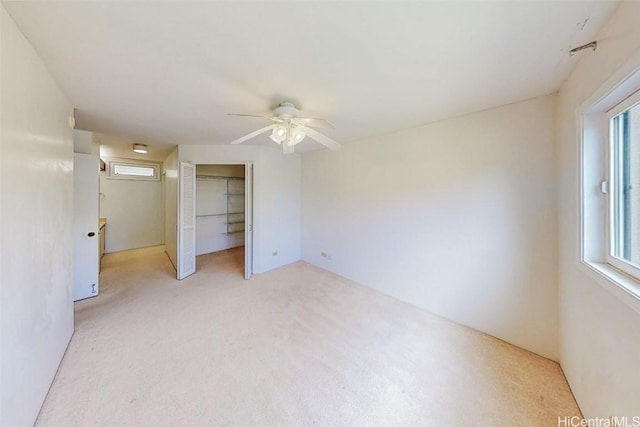 unfurnished bedroom with light colored carpet, a closet, and ceiling fan