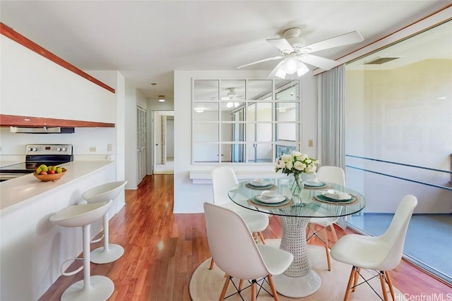 dining room featuring visible vents, a ceiling fan, and wood finished floors