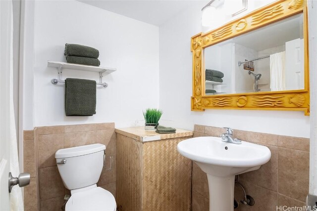 bathroom featuring tile walls and toilet