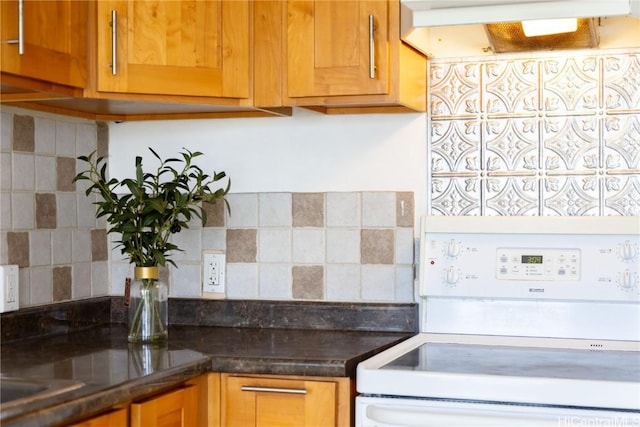 kitchen featuring dark stone countertops, electric range, and tasteful backsplash