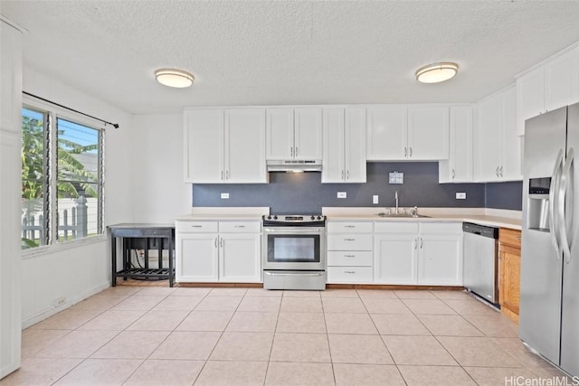 kitchen with sink, white cabinets, light tile patterned floors, and appliances with stainless steel finishes