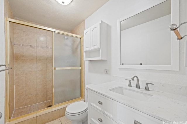 bathroom with toilet, walk in shower, tile patterned flooring, and vanity