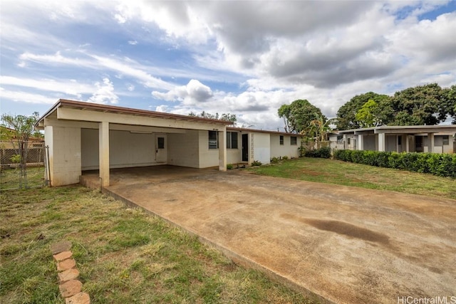 rear view of house with a carport and a yard