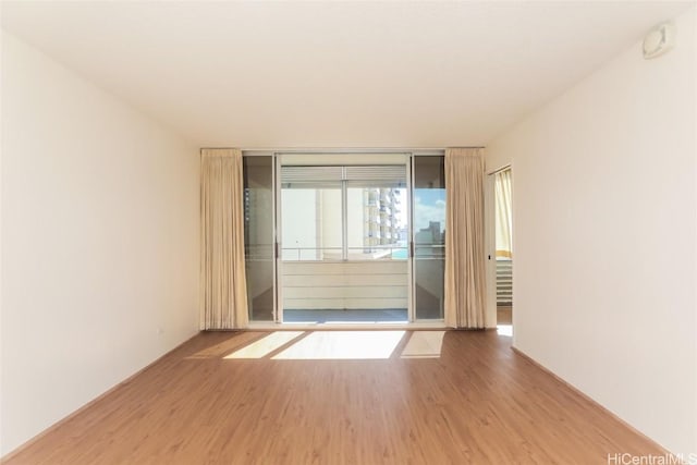 unfurnished room featuring expansive windows and wood finished floors