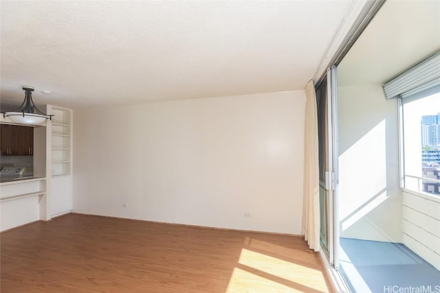 unfurnished living room featuring light wood finished floors and a textured ceiling