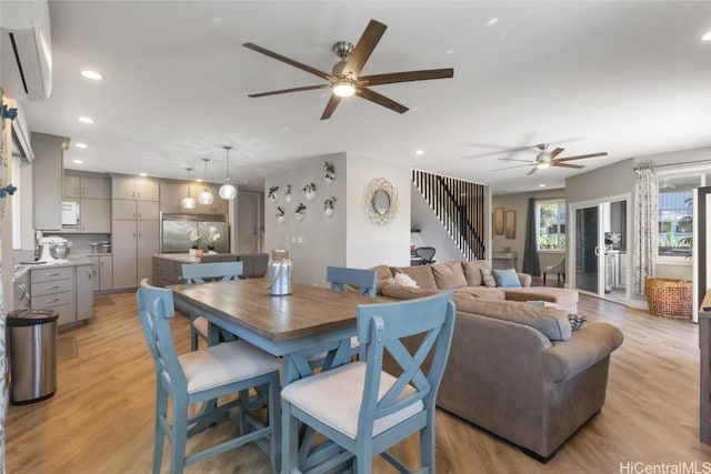 dining room featuring light hardwood / wood-style floors, ceiling fan, and a wall mounted air conditioner