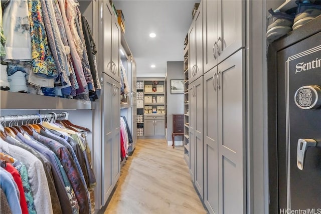 walk in closet with light hardwood / wood-style flooring