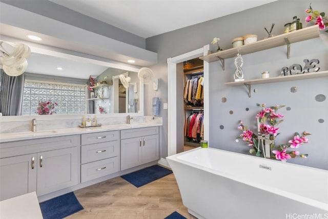 bathroom with a tub, wood-type flooring, and vanity