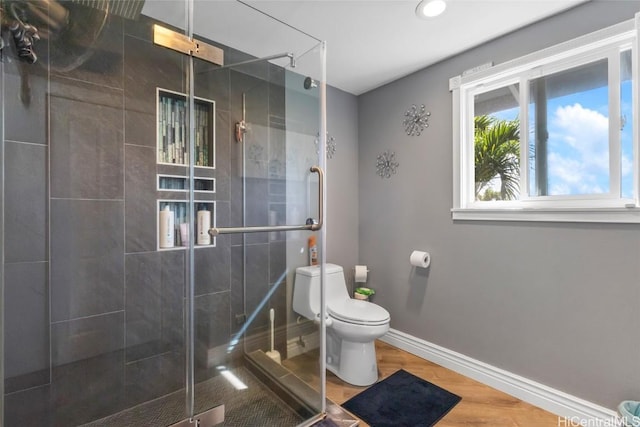 bathroom with hardwood / wood-style flooring, toilet, and walk in shower