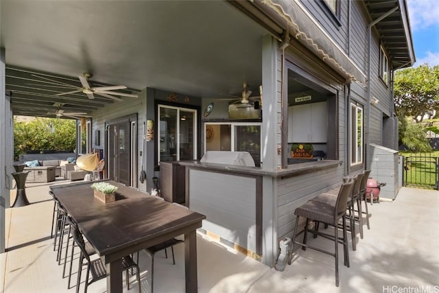 view of patio / terrace with ceiling fan and a bar