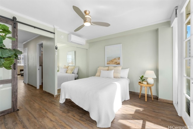 bedroom with a wall mounted air conditioner, a barn door, ceiling fan, and dark wood-type flooring