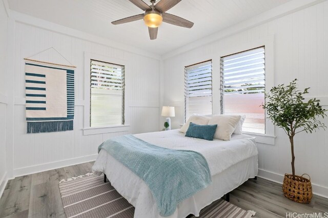 bedroom featuring wood finished floors, baseboards, and ceiling fan