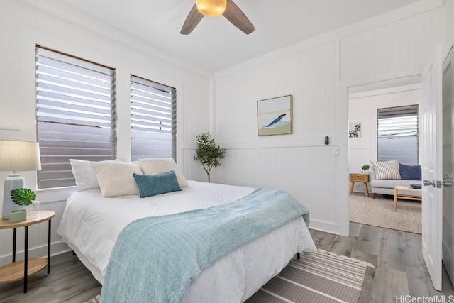 bedroom featuring multiple windows, ceiling fan, and light wood-type flooring