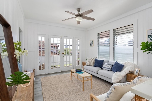 living room with ceiling fan, light hardwood / wood-style floors, crown molding, and french doors