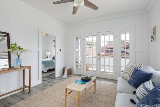 living room featuring ceiling fan, french doors, ornamental molding, and hardwood / wood-style flooring