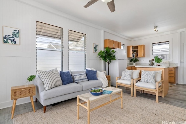 living room with light wood-type flooring, ceiling fan, and crown molding