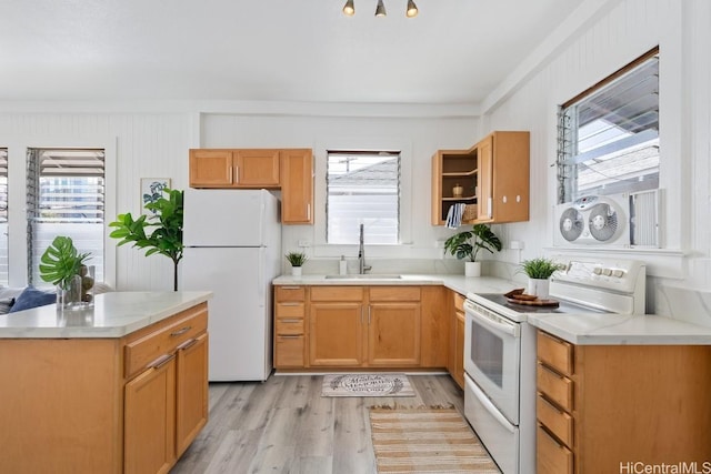 kitchen featuring white appliances, light countertops, light wood-style floors, and a sink