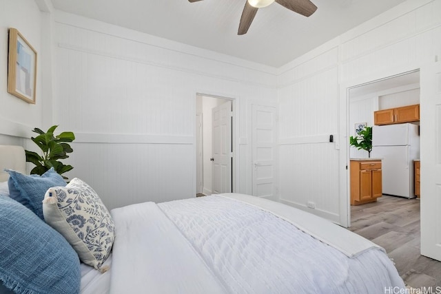 bedroom featuring ensuite bath, ceiling fan, white fridge, and light hardwood / wood-style floors