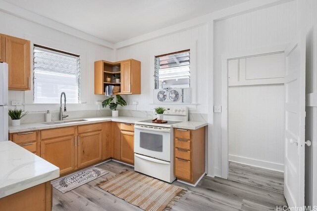 kitchen with light stone countertops, sink, white appliances, and light wood-type flooring