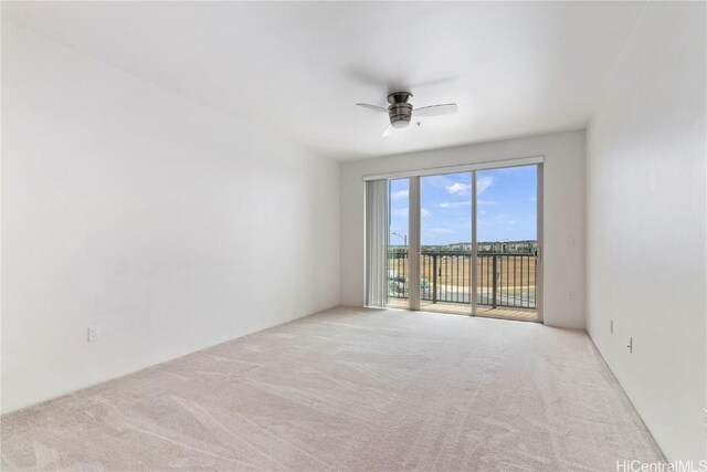 spare room with light colored carpet and ceiling fan