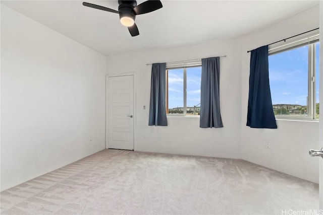 carpeted spare room featuring a ceiling fan