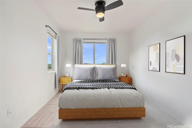 bedroom with ceiling fan and light carpet