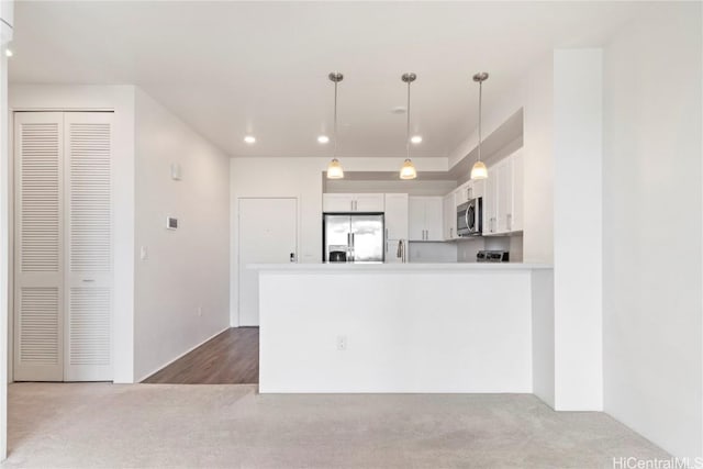 kitchen featuring white cabinetry, appliances with stainless steel finishes, pendant lighting, and kitchen peninsula