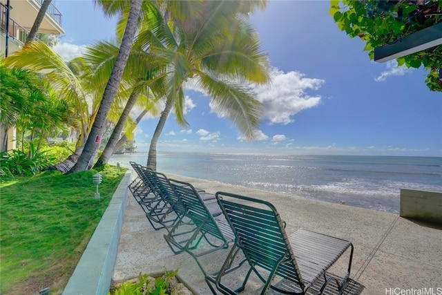 view of patio with a water view and a beach view